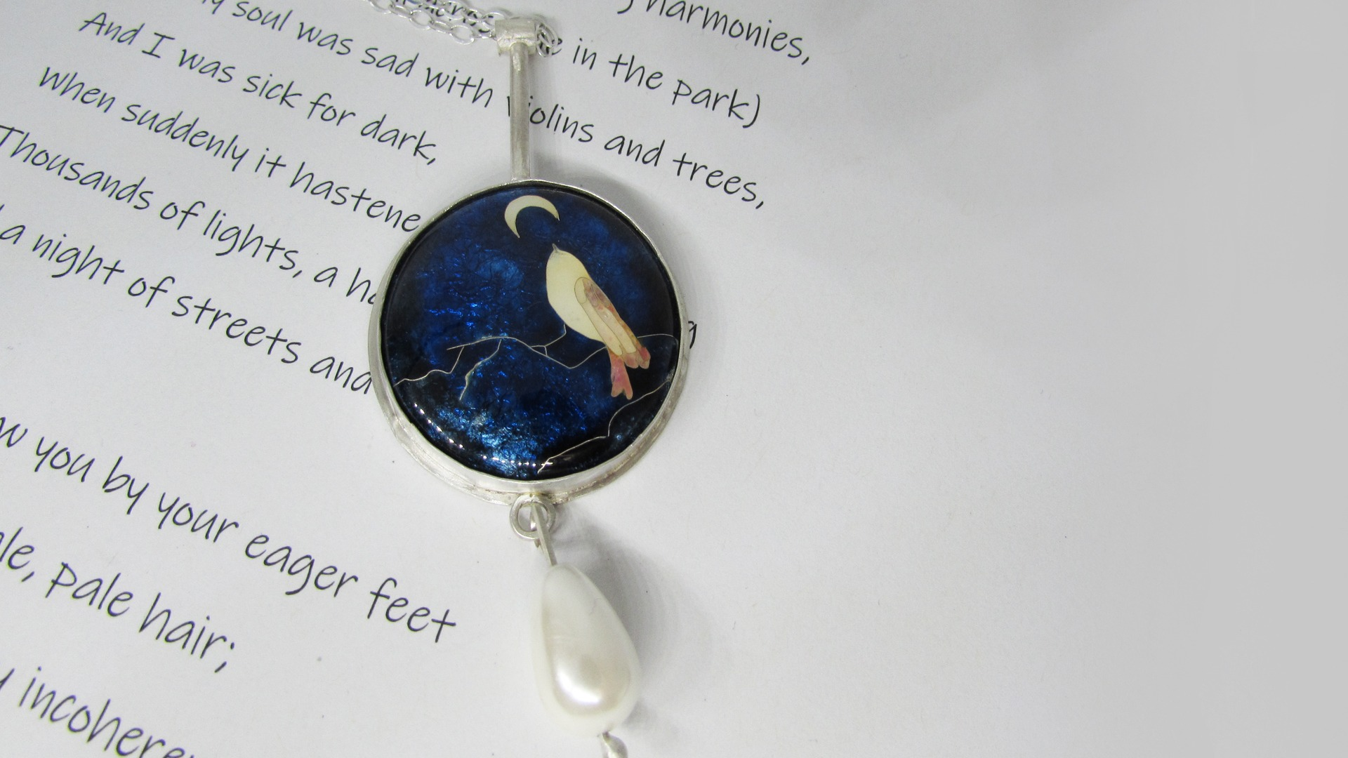 Bird in moonlight pendant is a cloisonne enamel piece set in silver and complemented by a pearl bead