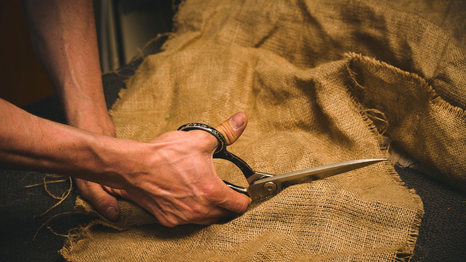 Photo of Edwin Fox cutting through fabric with upholstery scissors 